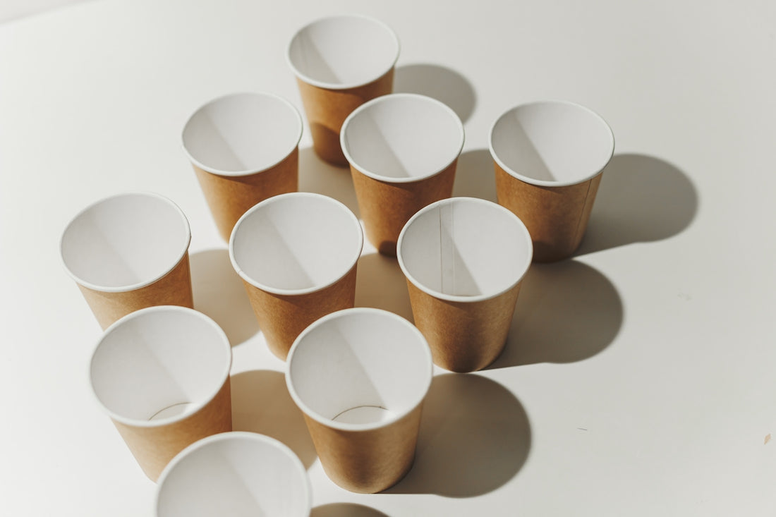 Several empty paper cups arranged on a white surface.